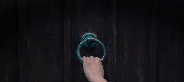 Female hand touching knocker